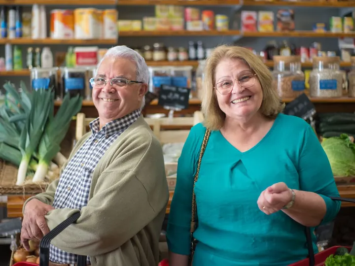 Un couple de seniors fait ses courses au rayon des légumes.